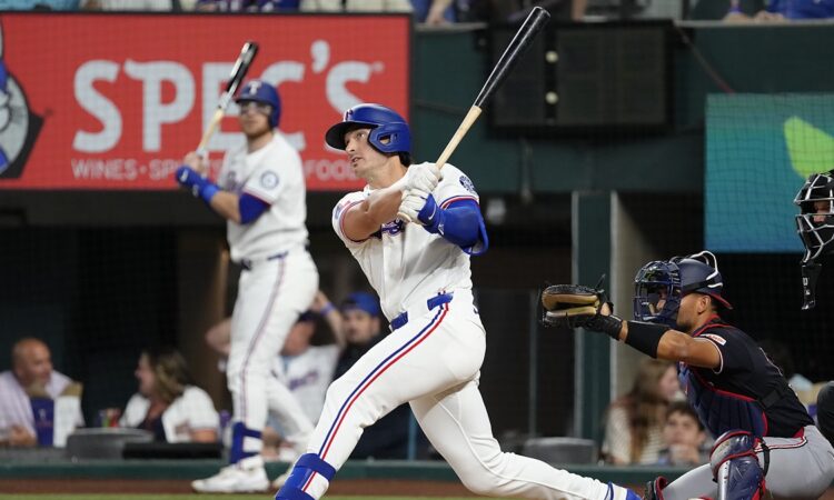 Texas Rangers designated hitter Justin Foscue watches his solo home run after finishing his swing.