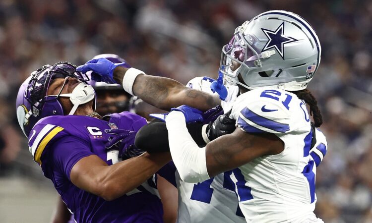 Minnesota Vikings wide receiver Justin Jefferson and Dallas Cowboys cornerback Caelen Carson grapple after a play.