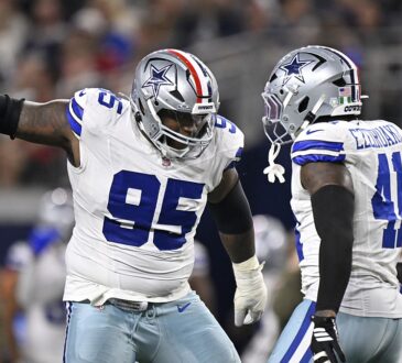 Cowboys defensive tackle Kenny Clark celebrates a sack alongside defensive end Donovan Ezeiruaku at midfield