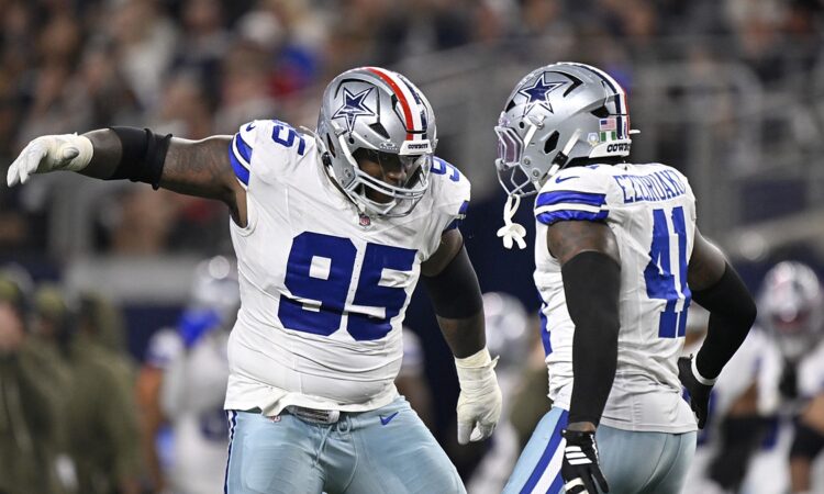 Cowboys defensive tackle Kenny Clark celebrates a sack alongside defensive end Donovan Ezeiruaku at midfield