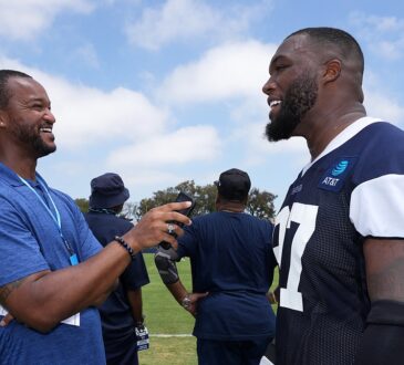 Cowboys defensive tackle Kenny Clark laughs during a sideline interview at training camp in his practice jersey