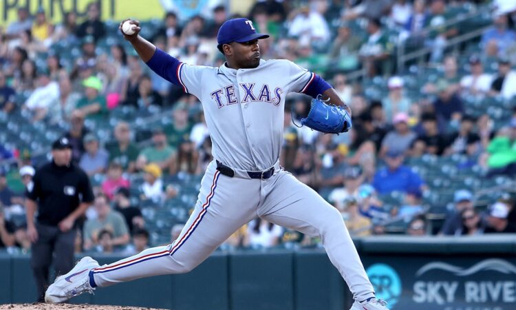 Texas Rangers starting pitcher Kumar Rocker strides toward the plate with the ball cocked behind him.