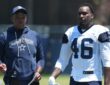 Dallas Cowboys tight ends coach Lunda Wells walks the practice field alongside tight end Michael Trigg in a No. 46 jersey.