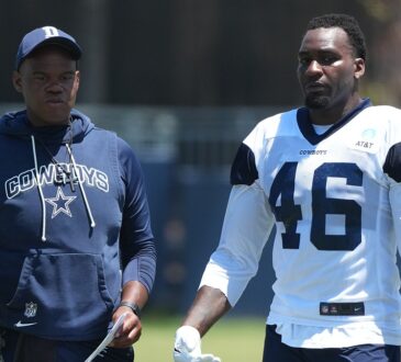 Dallas Cowboys tight ends coach Lunda Wells walks the practice field alongside tight end Michael Trigg in a No. 46 jersey.