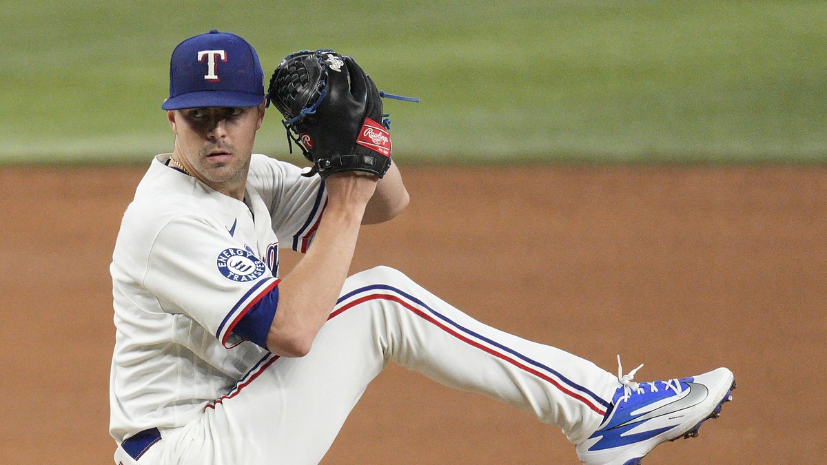 Texas Rangers pitcher MacKenzie Gore lifts his leg into the windup with his glove raised on the mound.