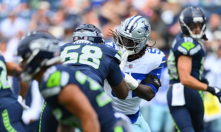 Dallas Cowboys linebacker Malachi Lawrence fights through the block of Seattle Seahawks offensive lineman Bryce Hart.