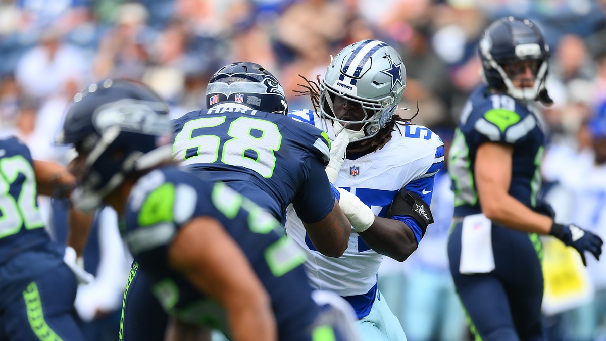 Dallas Cowboys linebacker Malachi Lawrence fights through the block of Seattle Seahawks offensive lineman Bryce Hart.