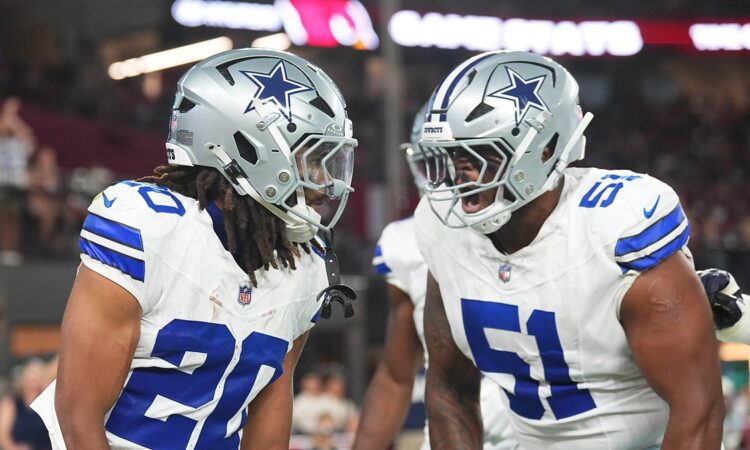 Dallas Cowboys running back Jaydon Blue hurdles an Arizona Cardinals defender on a first-half carry.