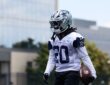 Dallas Cowboys running back Malik Davis carries a football in his left hand during a minicamp drill in his No. 20 practice jersey.