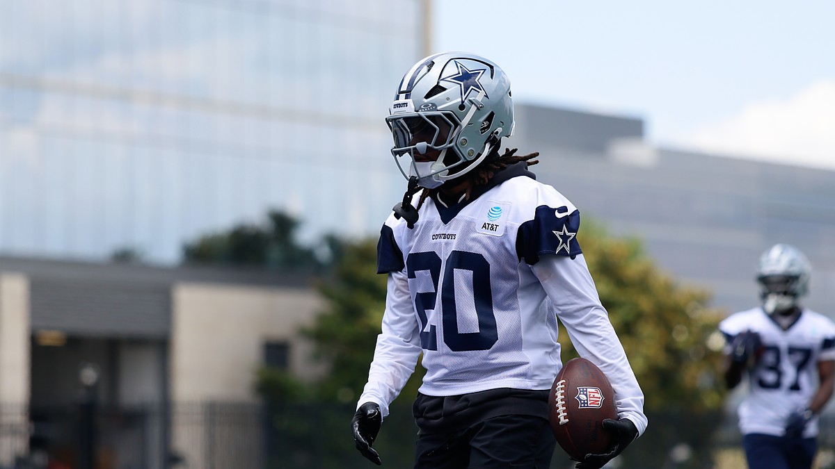 Dallas Cowboys running back Malik Davis carries a football in his left hand during a minicamp drill in his No. 20 practice jersey.