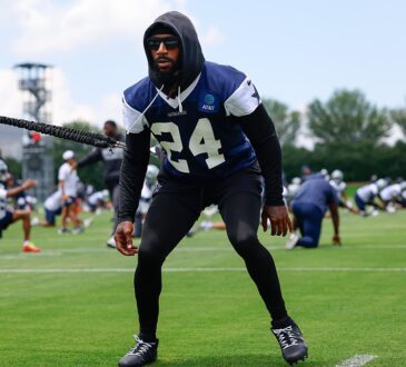 Dallas Cowboys safety Malik Hooker pulls against a resistance cord in a crouched stance during a practice drill.