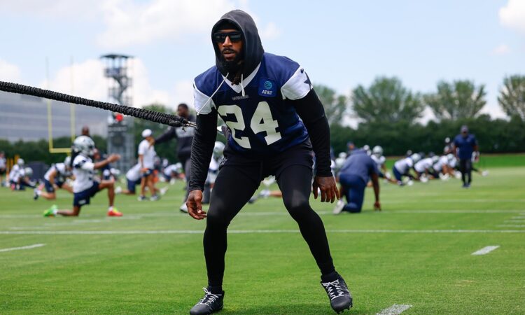 Dallas Cowboys safety Malik Hooker pulls against a resistance cord in a crouched stance during a practice drill.