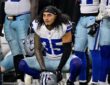 Dallas Cowboys linebacker Marist Liufau crouches on the sideline with his helmet on the turf in front of him.