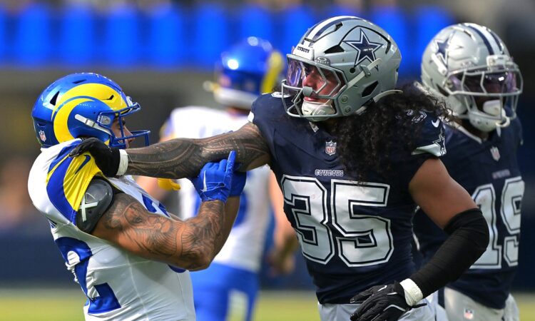 Dallas Cowboys linebacker Marist Liufau grabs Rams running back Cody Schrader by the shoulder after a play.