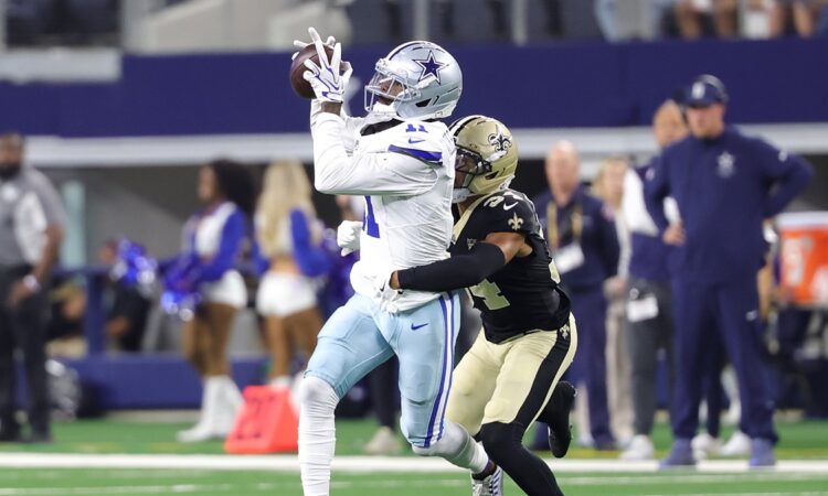 Dallas Cowboys wide receiver Marquez Valdes-Scantling hauls in a pass with a New Orleans Saints defender trailing.