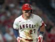 Los Angeles Angels center fielder Mike Trout jogs up the line in a dirt-streaked jersey after a base hit.