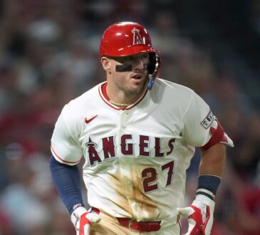 Los Angeles Angels center fielder Mike Trout jogs up the line in a dirt-streaked jersey after a base hit.