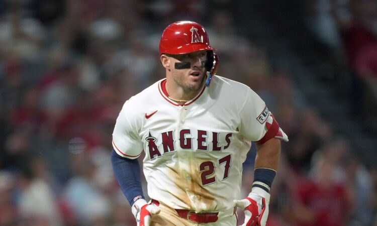 Los Angeles Angels center fielder Mike Trout jogs up the line in a dirt-streaked jersey after a base hit.