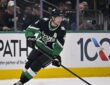 Dallas Stars defenseman Miro Heiskanen carries the puck up ice in a black home sweater during a playoff game.