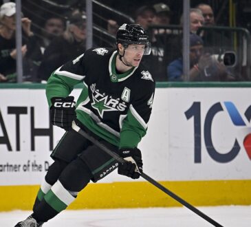 Dallas Stars defenseman Miro Heiskanen carries the puck up ice in a black home sweater during a playoff game.