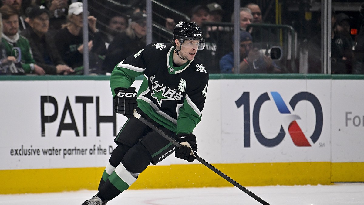 Dallas Stars defenseman Miro Heiskanen carries the puck up ice in a black home sweater during a playoff game.