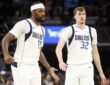Dallas Mavericks forwards Naji Marshall and Cooper Flagg slap hands as they walk upcourt against Memphis.
