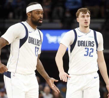 Dallas Mavericks forwards Naji Marshall and Cooper Flagg slap hands as they walk upcourt against Memphis.