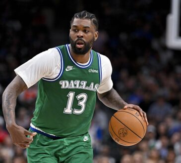 Dallas Mavericks forward Naji Marshall dribbles up the floor as a Los Angeles Clippers defender tracks the play.