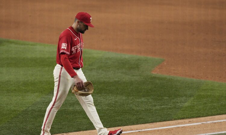 Texas Rangers pitcher Nathan Eovaldi walks off the field with his head down after being pulled against the Orioles.