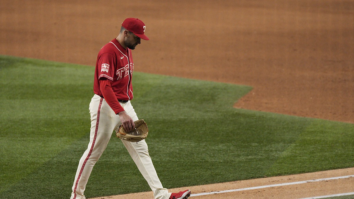 Texas Rangers pitcher Nathan Eovaldi walks off the field with his head down after being pulled against the Orioles.