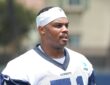Dallas Cowboys guard Nick Leverett looks toward the field in a white No. 51 practice jersey and skullcap.