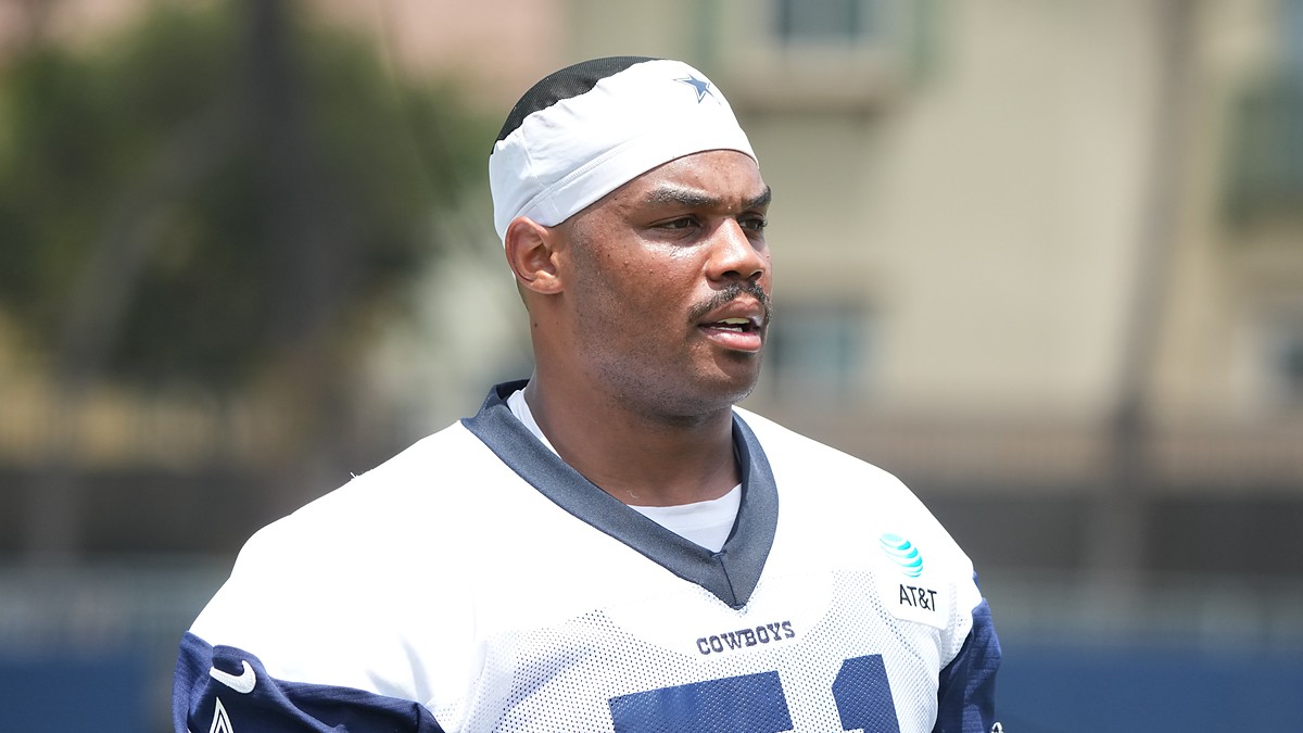 Dallas Cowboys guard Nick Leverett looks toward the field in a white No. 51 practice jersey and skullcap.