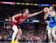 Dallas Wings guard Paige Bueckers rises to shoot as Indiana Fever guard Caitlin Clark contests with an outstretched hand.