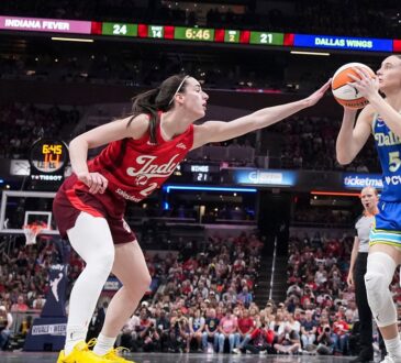 Dallas Wings guard Paige Bueckers rises to shoot as Indiana Fever guard Caitlin Clark contests with an outstretched hand.