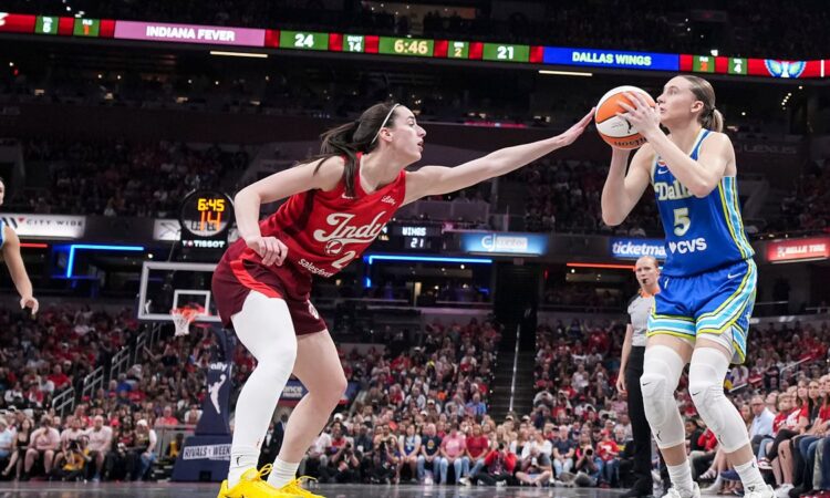 Dallas Wings guard Paige Bueckers rises to shoot as Indiana Fever guard Caitlin Clark contests with an outstretched hand.