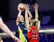 Dallas Wings guard Paige Bueckers rises for a jump shot over the outstretched arms of Portland Fire guard Karlie Samuelson.