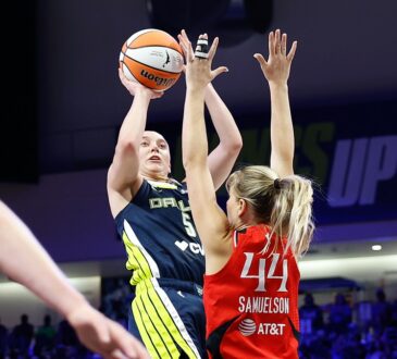 Dallas Wings guard Paige Bueckers rises for a jump shot over the outstretched arms of Portland Fire guard Karlie Samuelson.
