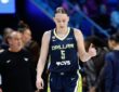 Dallas Wings guard Paige Bueckers gives a thumbs up while walking upcourt in her No. 5 jersey.