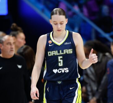 Dallas Wings guard Paige Bueckers gives a thumbs up while walking upcourt in her No. 5 jersey.