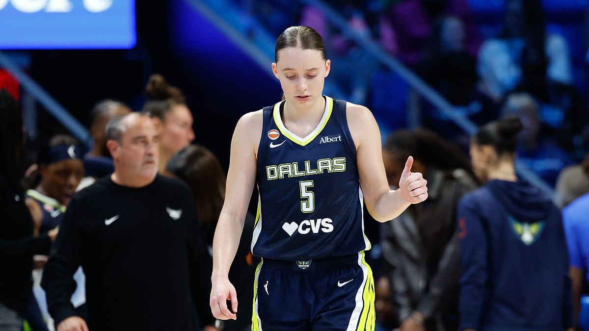 Dallas Wings guard Paige Bueckers gives a thumbs up while walking upcourt in her No. 5 jersey.
