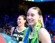 Dallas Wings guard Paige Bueckers holds a Reunion Tower lighting button draped in streamers after a win.