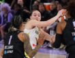 Dallas Wings guard Paige Bueckers looks for an outlet while trapped between two Golden State Valkyries defenders.