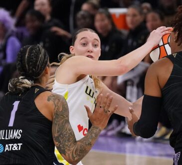 Dallas Wings guard Paige Bueckers looks for an outlet while trapped between two Golden State Valkyries defenders.