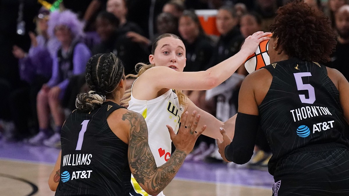 Dallas Wings guard Paige Bueckers looks for an outlet while trapped between two Golden State Valkyries defenders.
