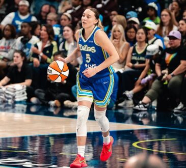 Dallas Wings guard Paige Bueckers dribbles up the floor in a blue Dallas jersey during a game.