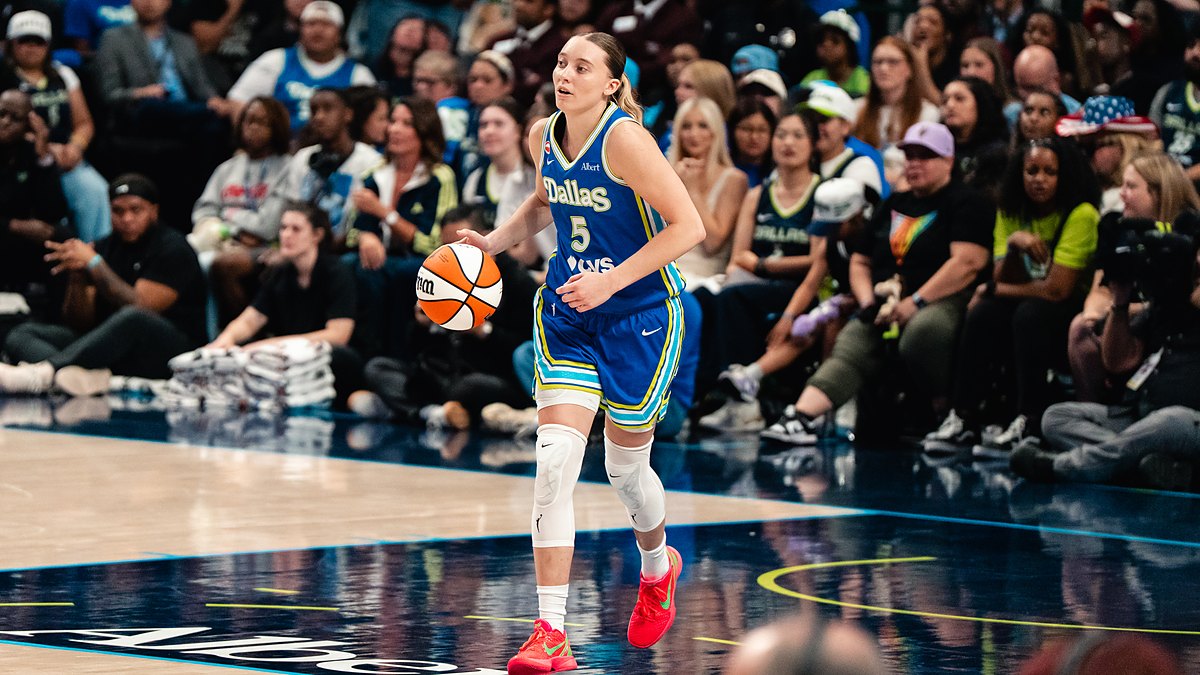 Dallas Wings guard Paige Bueckers dribbles up the floor in a blue Dallas jersey during a game.