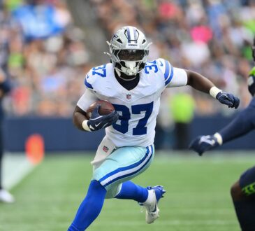 Dallas Cowboys running back Phil Mafah cuts upfield with the ball after a catch as a Seattle Seahawks defender closes in.
