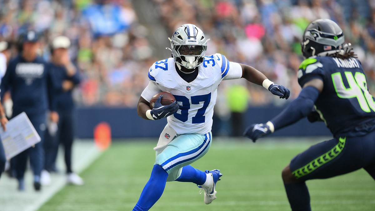 Dallas Cowboys running back Phil Mafah cuts upfield with the ball after a catch as a Seattle Seahawks defender closes in.