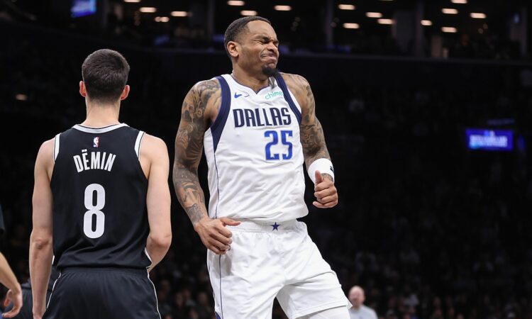 Dallas Mavericks forward P.J. Washington grimaces after an injury as Brooklyn Nets guard Egor Dëmin looks on.