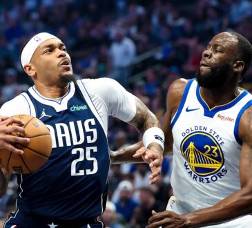 Dallas Mavericks forward P.J. Washington gathers the ball to drive as Golden State Warriors forward Draymond Green defends.